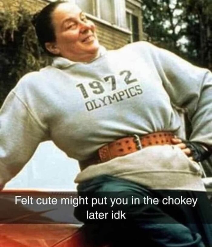 Woman in 1972 Olympics sweatshirt and weightlifting belt posing with a nostalgic 90s vibe and humorous caption about the chokey.