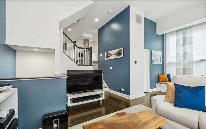 Modern living room with blue walls and wooden floor in a home showing creative home design ideas that failed.