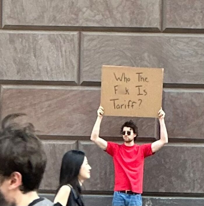 Man in red shirt holding sign with sarcastic message, example of Dude With The Sign expressing unspoken thoughts in public.