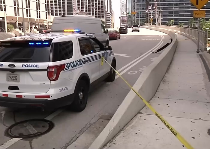 Police SUV with flashing lights blocks road near rising drawbridge where woman was rescued after holding on for dear life Police SUV with flashing lights blocks road near rising drawbridge where woman was rescued after holding on for dear life