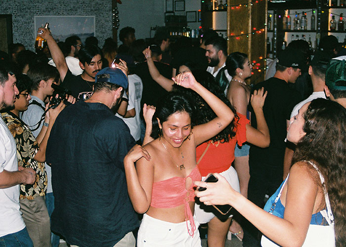 Crowded party scene with people dancing and socializing, capturing moments of fun and wild cheating stories.