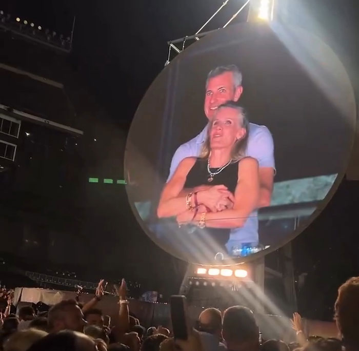 Couple embracing at Coldplay concert with crowd below, related to Coldplay HR exec mortgage news. - 5