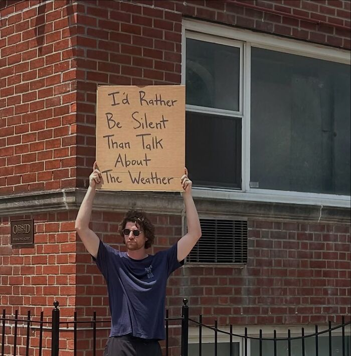 Man holding a sign with a relatable message, capturing a Dude With The Sign moment expressing common thoughts silently.