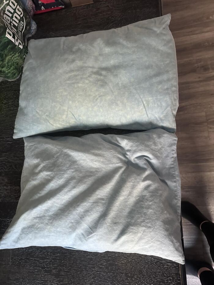 Two pillows placed on a table with a floor visible, showcasing a real-life glitch in the matrix moment.