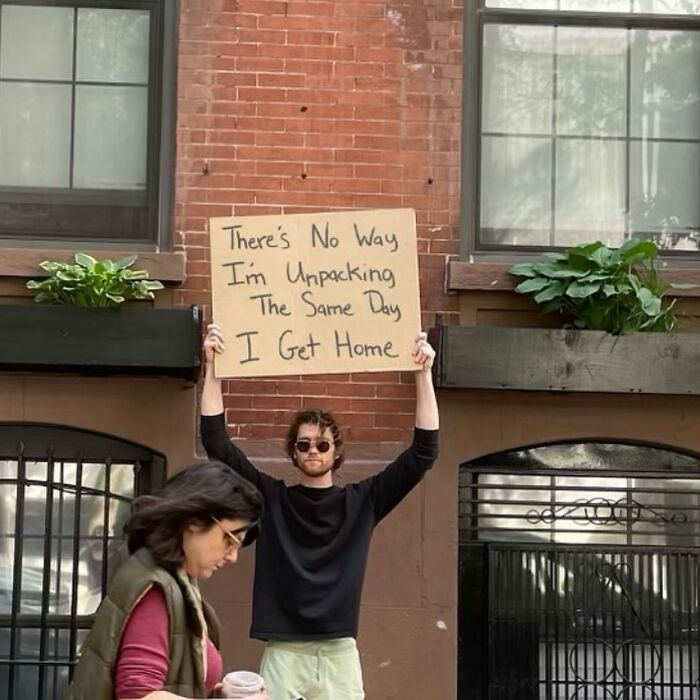 Man holding a cardboard sign with a humorous message in a city setting, featuring dude with the sign content.