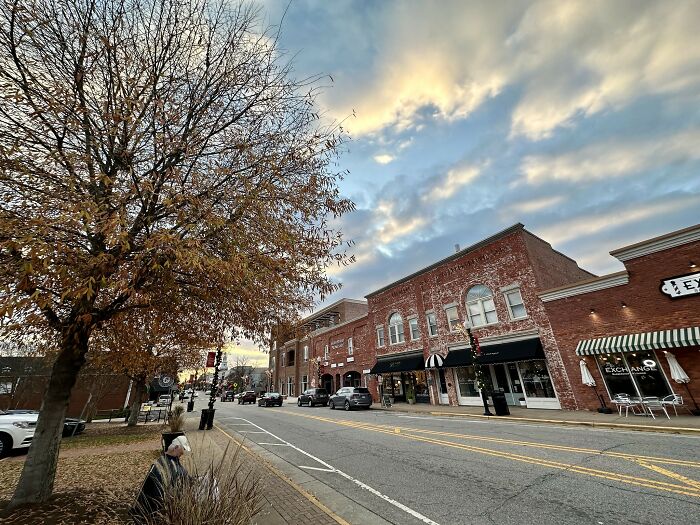 Small town street scene with brick buildings and autumn trees, illustrating the best places to live in the USA.
