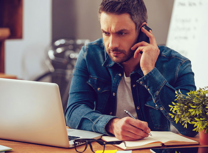 Man in denim jacket messaging after every client call, looking focused and ignored for three hours while working at desk. - 13