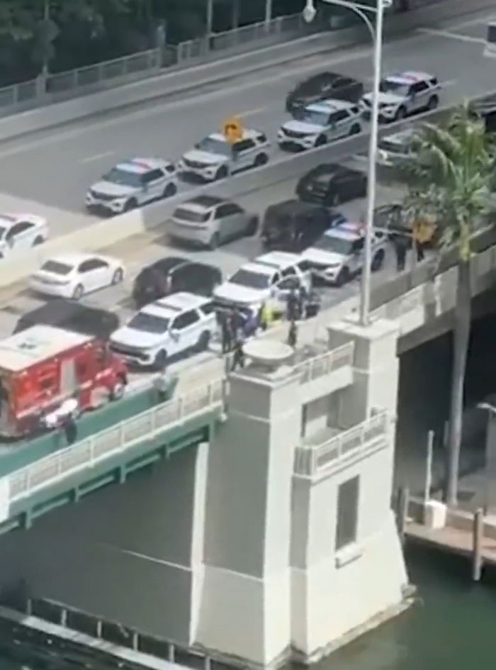 Emergency vehicles and police responding at a drawbridge where a woman survived holding on to the rising bridge. Emergency vehicles and police responding at a drawbridge where a woman survived holding on to the rising bridge.