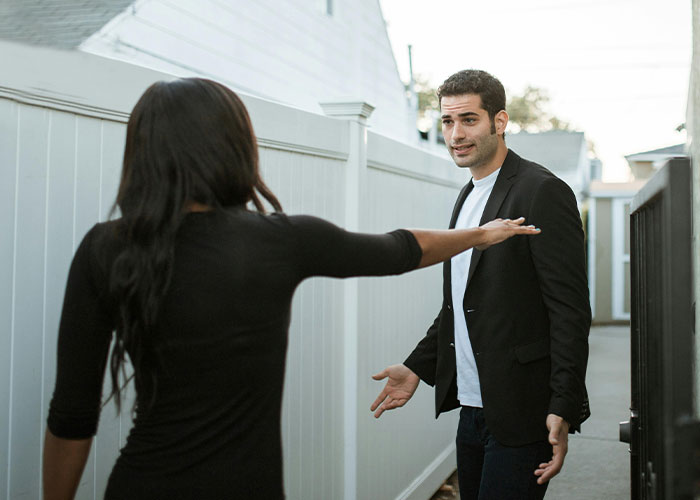 A woman confronts a man outside, illustrating emotional tense moments in worst cheating stories.