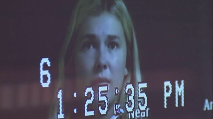 Close-up of a woman’s face with a digital timestamp overlay, illustrating moments related to job loss consequences.
