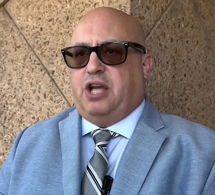 Man wearing sunglasses and a suit speaking outside court about baby lost in car while mom got lip filler charges - 8