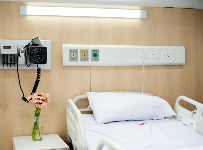 Hospital room with empty bed and flowers, symbolizing support group response after woman ended her own life by starving. - 2
