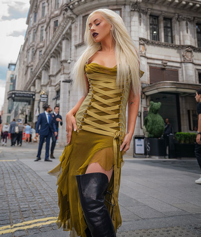Christina Aguilera in olive green dress and black boots during latest public appearance sparking health concerns in urban setting. Christina Aguilera in olive green dress and black boots during latest public appearance sparking health concerns in urban setting.