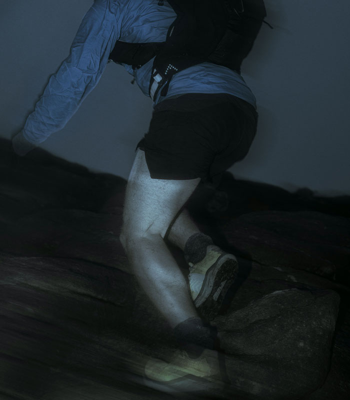 Person hiking at night on rocky terrain, capturing real-life horror stories of unexplainable encounters in the dark. - 4