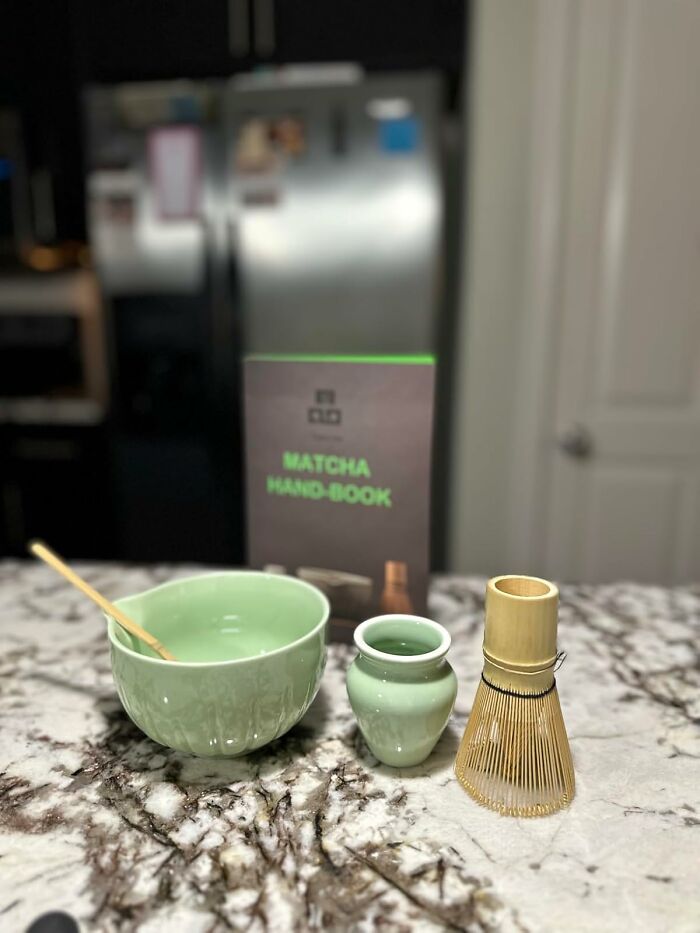 Matcha tea set with bowl, whisk, and book on a marble countertop showcasing Prime Day treasures.