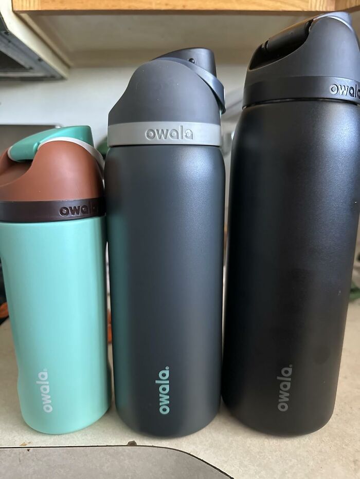 Three Owala insulated water bottles in different sizes and colors lined up on a kitchen counter, best sellers on Prime Day.
