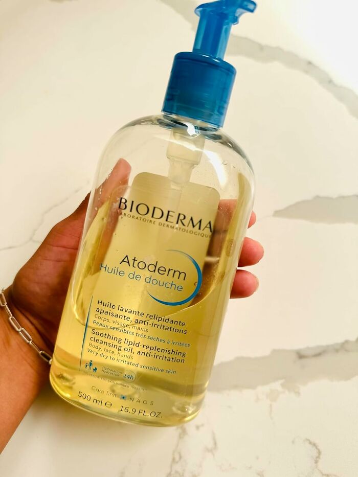 Hand holding Bioderma Atoderm cleansing oil, a best seller topping the charts in skincare products this past Prime Day.