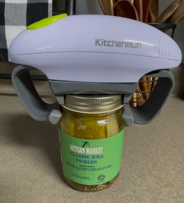 Electric jar opener from TikTok Shop finds gripping a pickle jar on a kitchen counter with utensils in background
