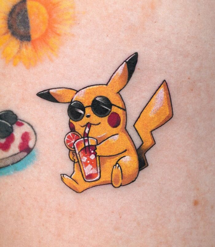 Tattoo of Pikachu wearing sunglasses and drinking a cocktail, showcasing one of the best tattoos people love and like.