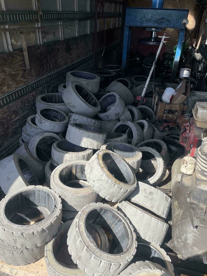 Pile of worn-down tires in a dimly lit workshop, showcasing an epic work fail in tire storage and maintenance.