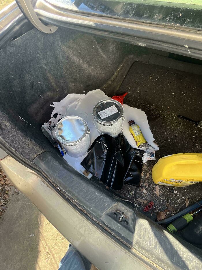 Car trunk with spilled paint and various tools showing an epic work fail mess no one wants to encounter.