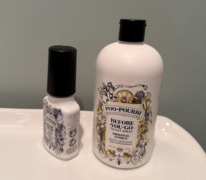 Two P*o-Pourri original citrus toilet spray bottles displayed on a white bathroom sink, a popular 5-star Prime Day find.