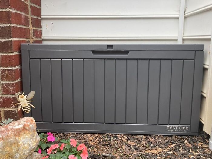Gray outdoor storage box placed against house exterior wall with flowers nearby, one of the 5-star Prime Day finds.