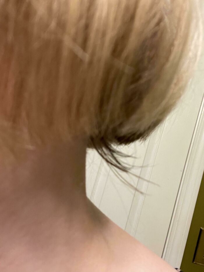 Close-up of a short, uneven haircut showing a salon glow-up fail with messy hair strands.