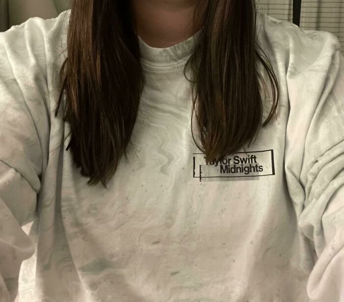 Person wearing a stained Taylor Swift Midnights sweatshirt after a salon visit, reflecting a glow-up gone wrong moment.