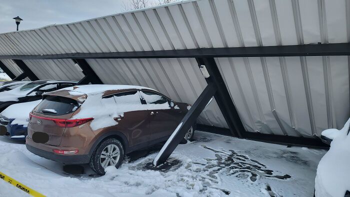 Car trapped under a collapsed roof in snowy parking lot, showing people experiencing unbelievable luck moments.