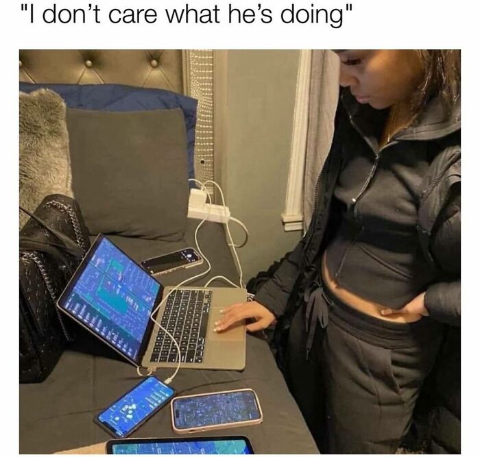 A girly woman in casual clothes focused on multiple screens and devices, showcasing funny and relatable memes.