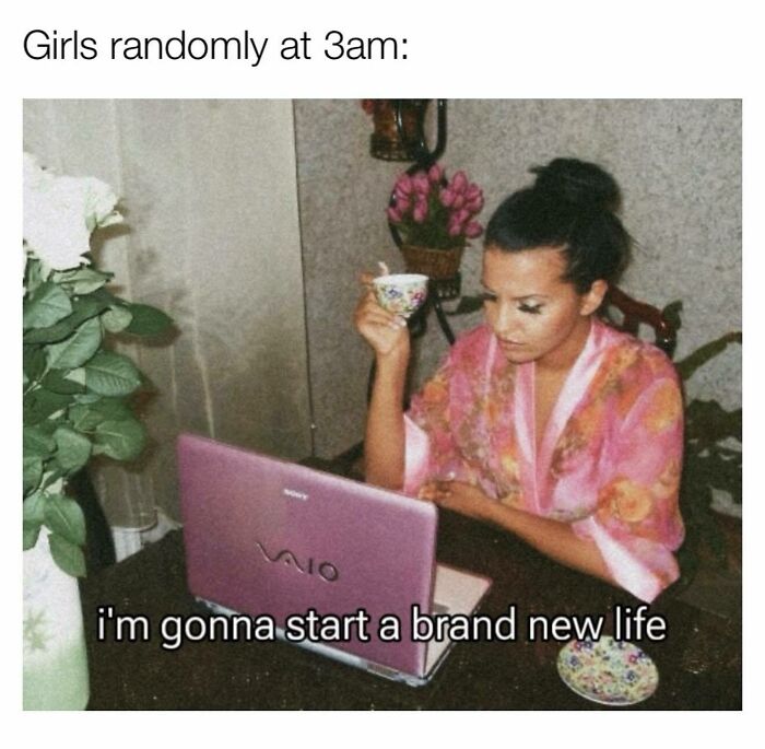 Woman in a floral robe drinking tea at night, using a pink laptop, funny and relatable memes for girly women.