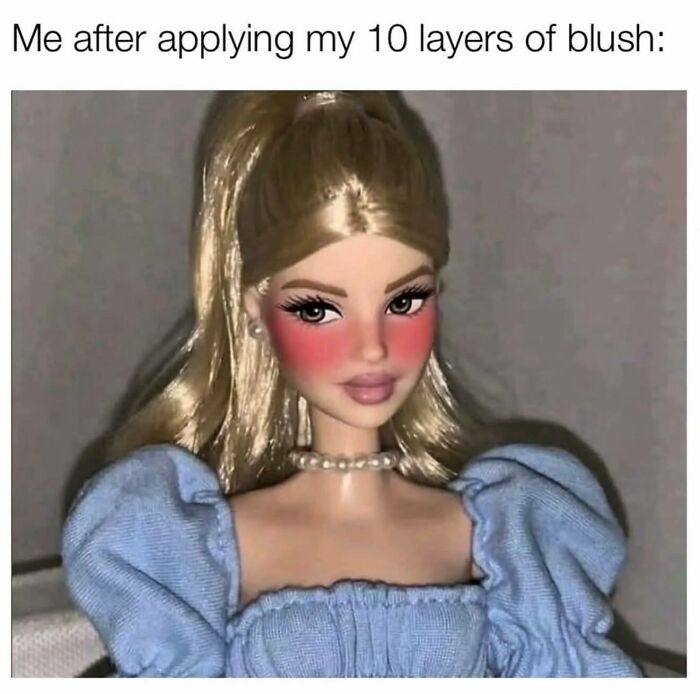 Blonde doll with exaggerated pink blush on cheeks wearing a blue dress and pearl necklace in a funny girly women meme.