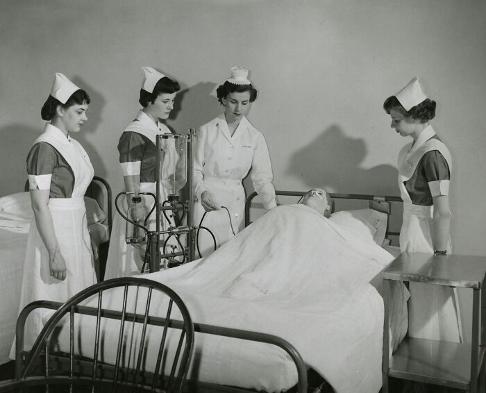 Vintage nurses in traditional uniforms caring for a patient in a hospital bed, showcasing healing and hope.