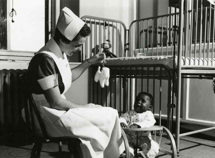Vintage photo of a nurse caring for a baby, showcasing nurses who brought healing and hope in the past.