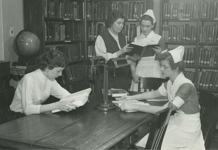 Vintage photo of nurses studying together in a library, showcasing classic nursing uniforms and dedication to healing and hope.