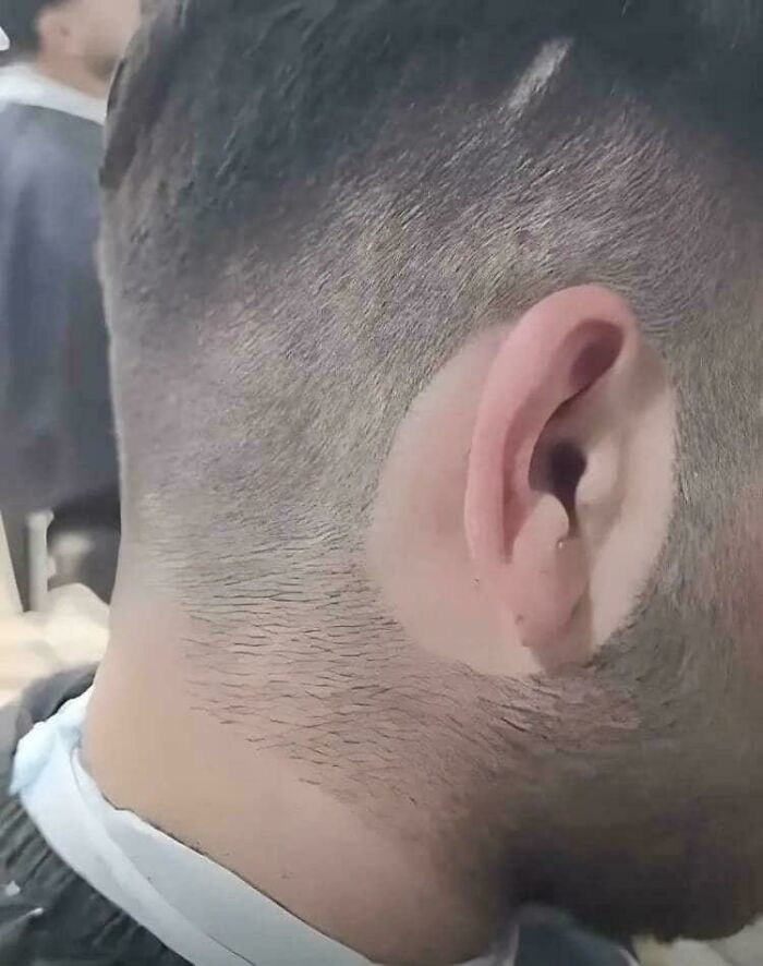 Close-up of a man’s uneven haircut at a salon, highlighting a disappointing glow-up and salon breakdown experience.