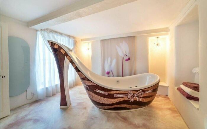 Bathroom with a high-heel shoe shaped bathtub featuring decorative patterns in an unusual real estate listing design.