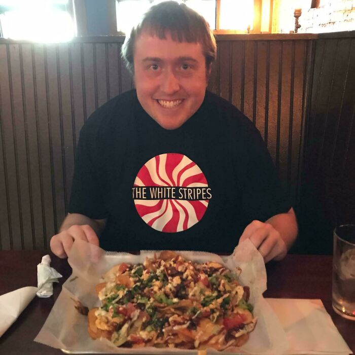 Young man smiling with messy hair after a salon visit, illustrating glow-up and emotional breakdown experiences.