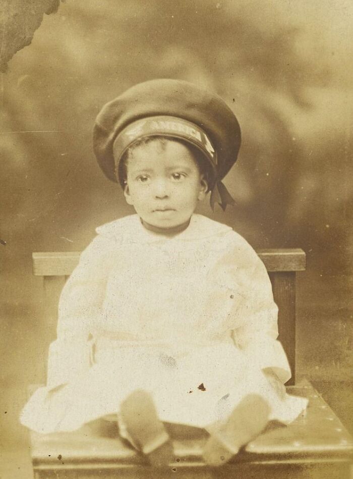 Sepia-toned vintage postcard featuring a young child in early 20th century attire, capturing the heart of 1930s nostalgia.