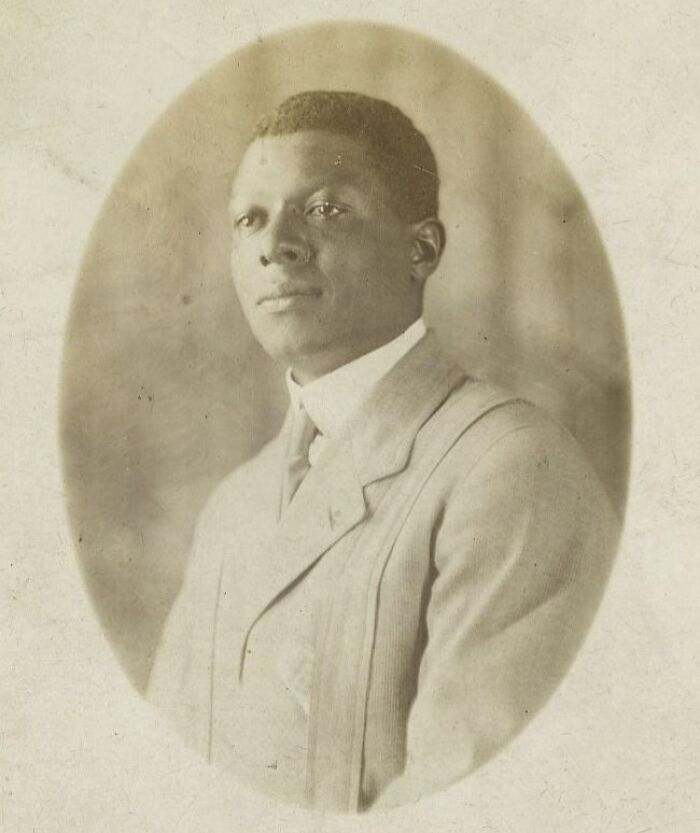 Vintage postcard portrait of a young man from the 1930s wearing a suit with a high-collar shirt in an oval frame.