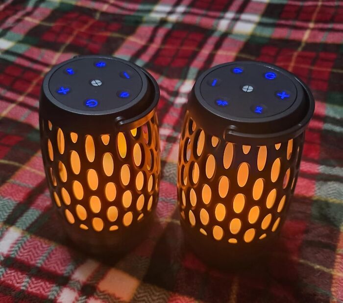 Two portable electronic speakers with glowing orange lights and blue control buttons on a plaid surface, showcasing Prime Day deals.
