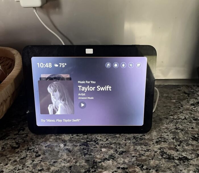 Smart display on granite countertop showing Taylor Swift music, highlighting Prime Day electronic deals for music lovers.