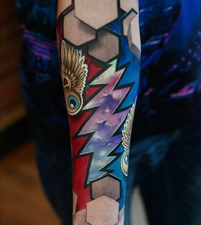 3D tattoos by Jesse Rix on forearm featuring vivid cosmic portal design with geometric and winged eye elements in bold colors.