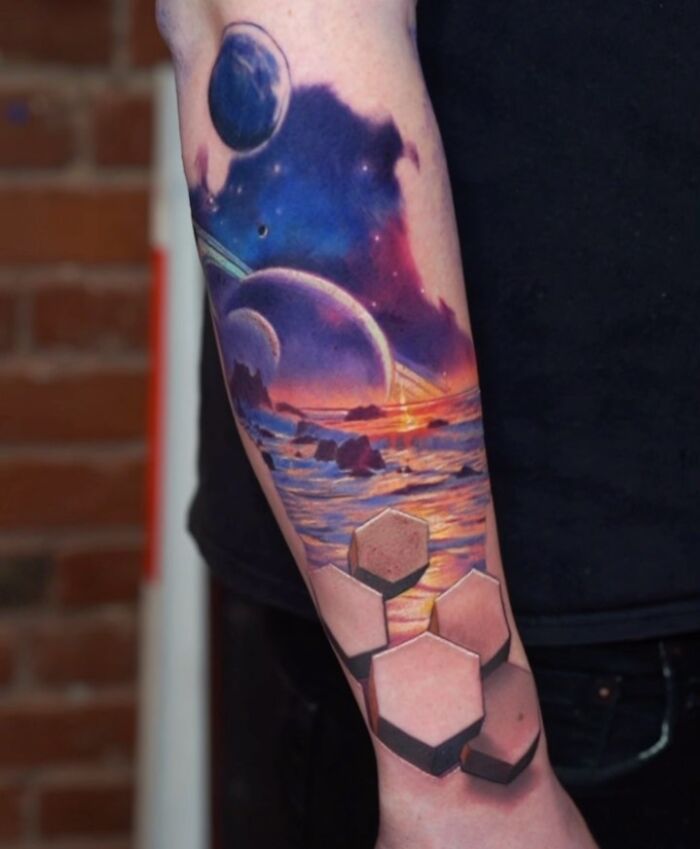 3D tattoos on forearm featuring a cosmic sunset landscape with planets and geometric shapes, showcasing portal-like design.