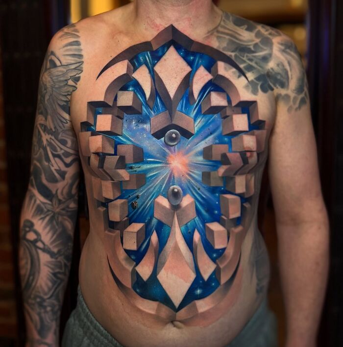3D tattoo on chest by Jesse Rix creating a portal to another world with geometric shapes and cosmic blue colors.