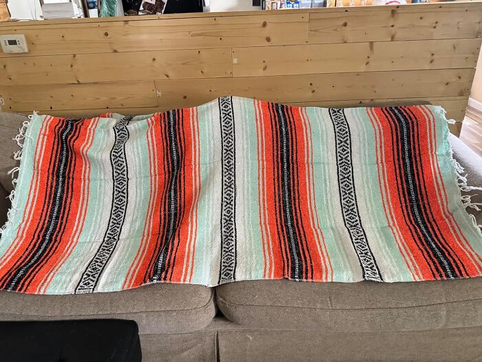 Colorful striped blanket draped over a couch, perfect for cozy Prime Day deals under 25 dollars to save your bank account.