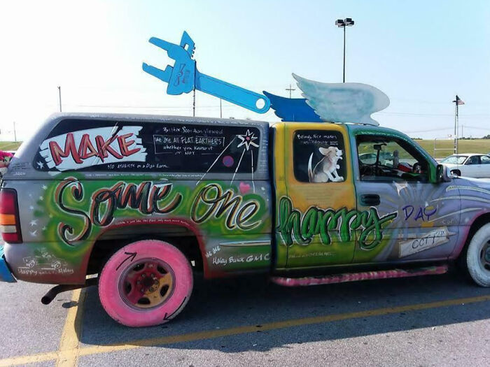 Colorfully painted truck with oversized wrench and wing car mods showcasing outrageous car mods creativity in parking lot.