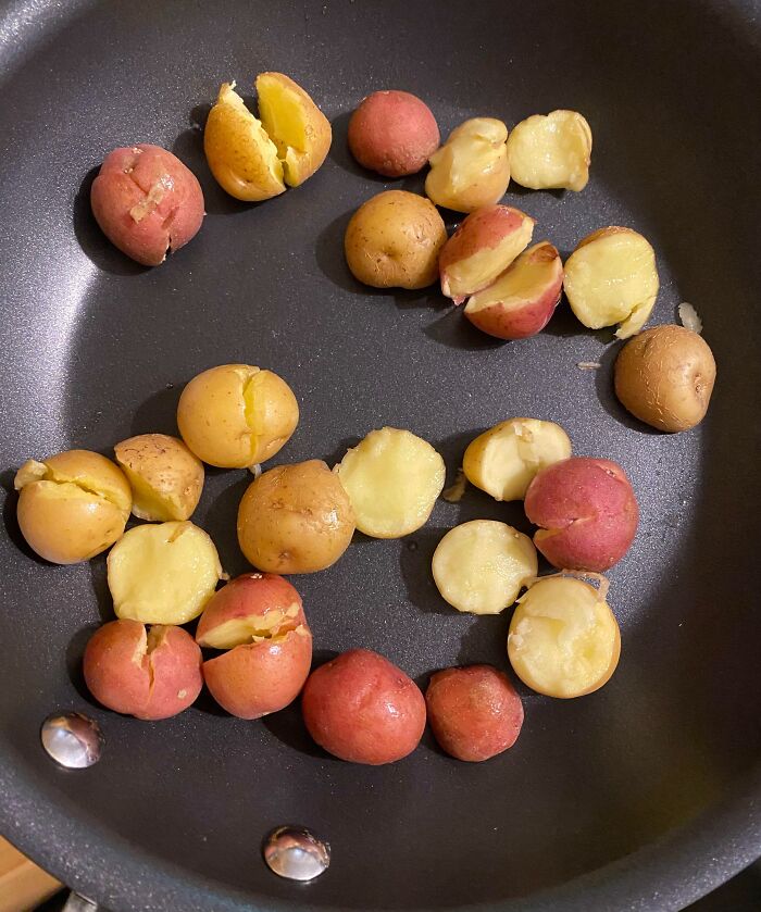 Small red and yellow potatoes c*****d open in a pan, illustrating a hilarious clueless partner cooking fail.
