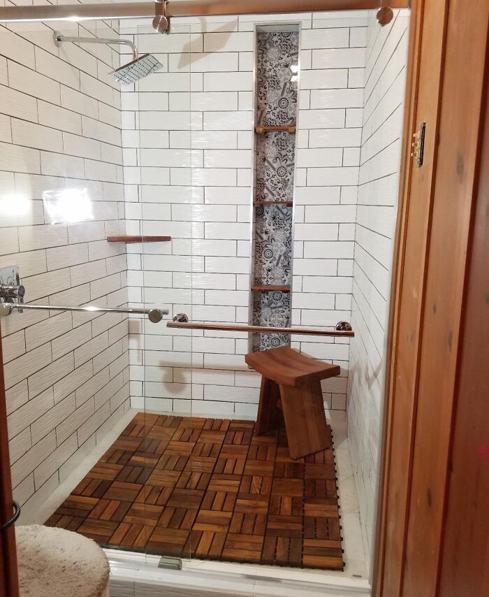 Modern shower with wood flooring and stool, showcasing creative home decor ideas to make your home fun and lively.